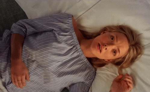 Woman in Blue and White Striped Shirt Laying on Bed
