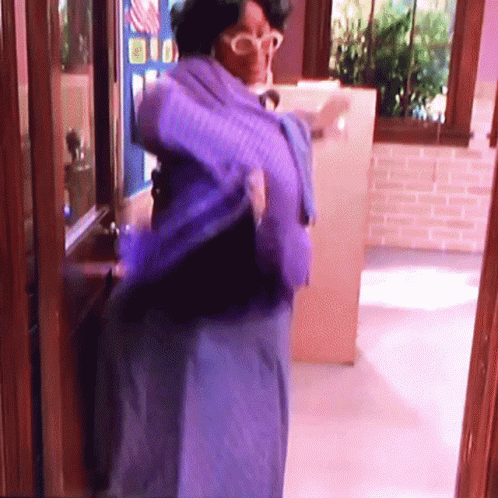 Woman In Blue Dress And Glasses At Window GIF