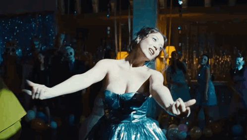 Woman in Blue Dress Dancing in Crowded Room