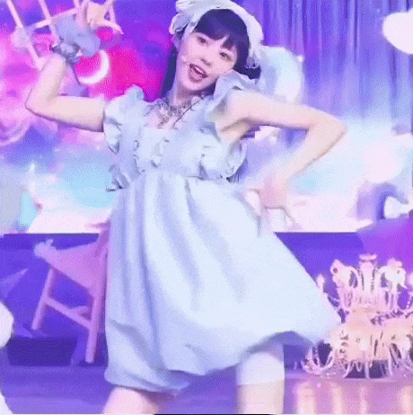 Woman in Blue Dress Dancing on Stage With Chandelier