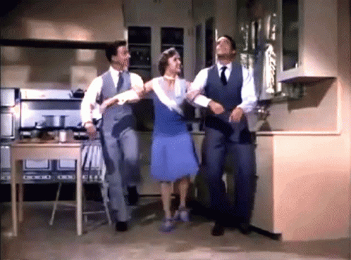 Woman in Blue Dress Dancing With Two Men in Suits
