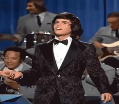 Woman In Blue Dress Holding Glass Asks About Love Spell GIF
