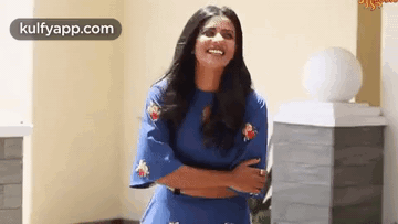 Woman in Blue Dress Laughing With Arms Crossed