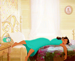 Woman In Blue Dress Laying On Bed With Alarm Clock GIF