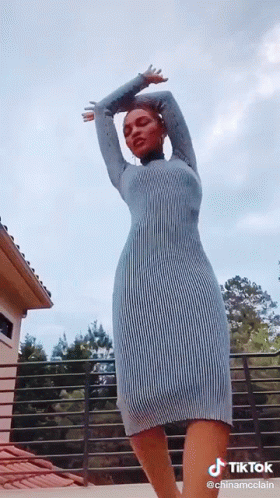 Woman in Blue Dress on Balcony