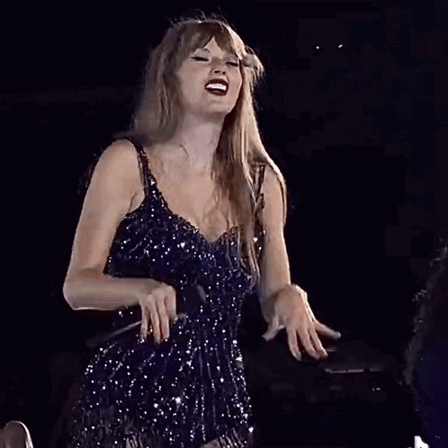 Woman in Blue Dress Singing Into Microphone