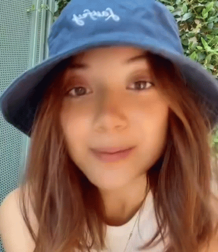 Woman in Blue Hat and White Shirt Smiling