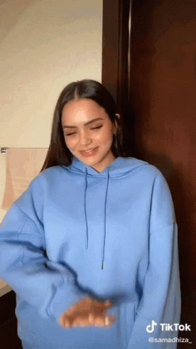 Woman in Blue Hoodie Smiling and Dancing