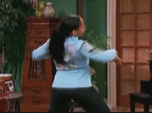 Woman In Blue Jacket And Black Pants Dancing GIF