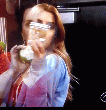 Woman In Blue Jacket Drinking From Bottle GIF