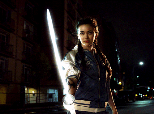 Woman in Blue Jacket Holding Light Saber