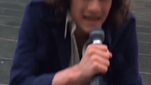 Woman in Blue Jacket Holding Microphone