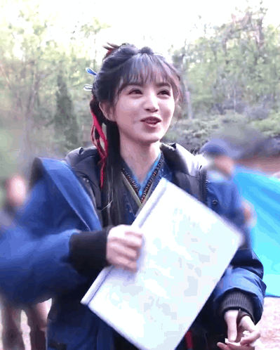 Woman in Blue Jacket Holding Paper