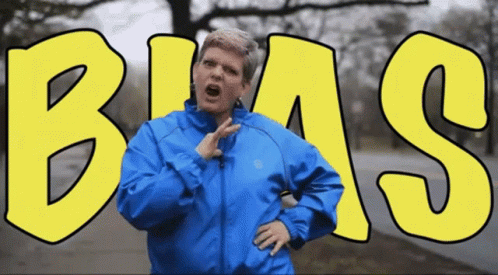Woman in Blue Jacket in Front of Bias Sign