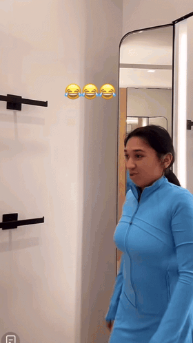 Woman In Blue Jacket Laughing At Mirror GIF