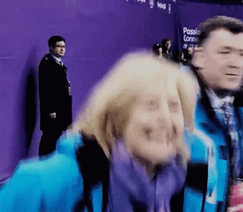 Woman In Blue Jacket Making Funny Face, Man Behind GIF