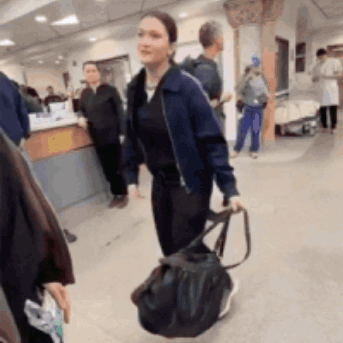 Woman in Blue Jacket Walking With Black Bag