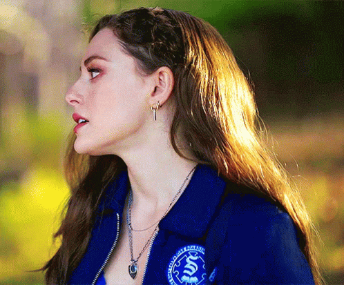 Woman in Blue Jacket With S Necklace