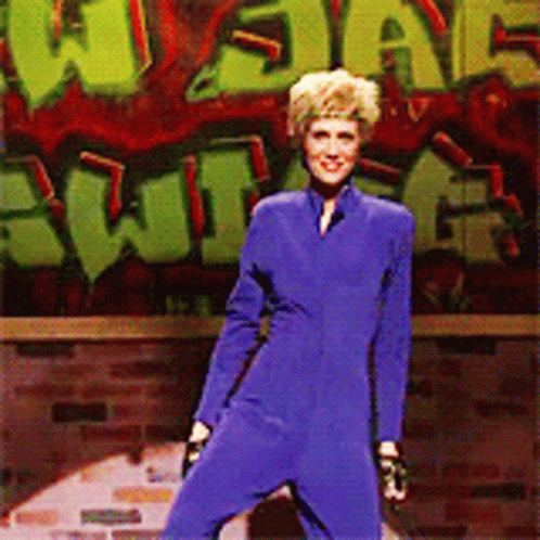 Woman in Blue Jumpsuit With Graffiti Saying What