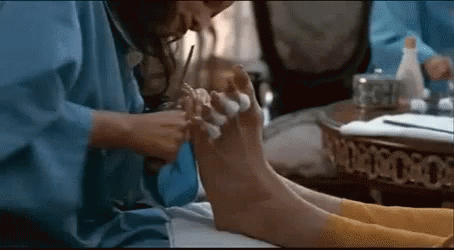 Woman in Blue Robe Giving Pedicure