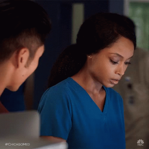 Woman in Blue Scrubs Looking at Man