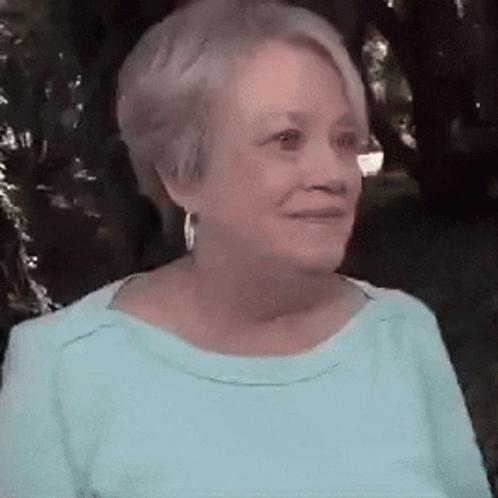 Woman in Blue Shirt and Earrings Smiling