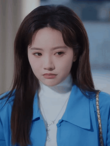Woman in Blue Shirt and White Turtleneck Looking at Camera