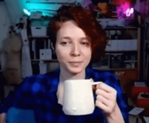 Woman in Blue Shirt Holding White Mug