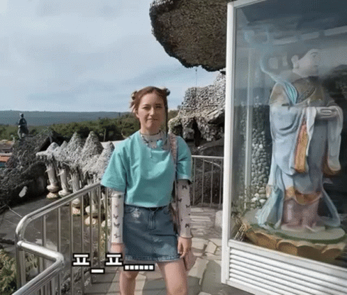 Woman In Blue Shirt In Front Of Statue GIF