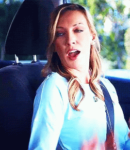 Woman in Blue Shirt Sitting in Back Seat Mouth Open