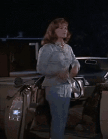Woman In Blue Shirt Standing Next To Car At Night GIF
