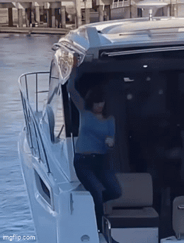 Woman in Blue Shirt With Arms Up on Boat
