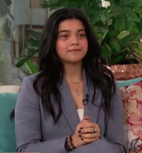 Woman in Blue Suit Sitting on Couch Smiling