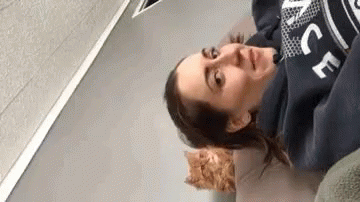 Woman in Blue Sweatshirt Laying on Bed Next to Cat