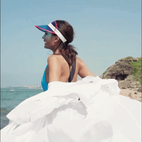 Woman in Blue Swimsuit Pink-White Visor on Beach