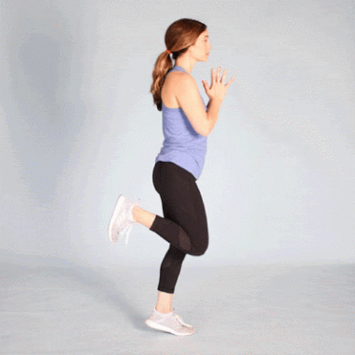 Woman in Blue Tank Top and Black Leggings Jumping