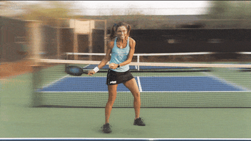 Woman in Blue Tank Top and Black Skirt Holding Tennis Racquet