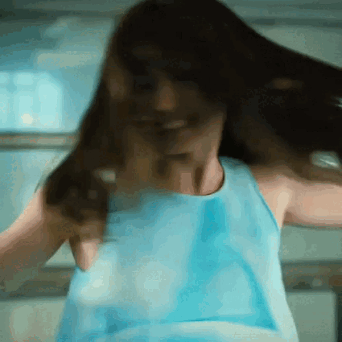 Woman in Blue Tank Top Dancing With Hair Flying