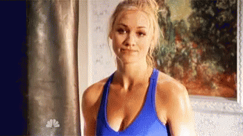 Woman in Blue Tank Top Smiling in Front of Painting
