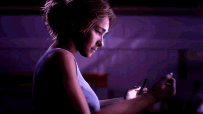 Woman In Blue Tank Top Using Cell Phone In Dark Room GIF