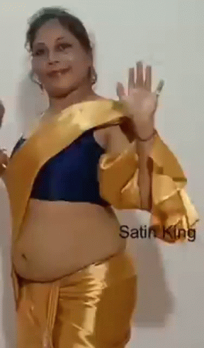 Woman in Blue Top and Gold Pants Waving