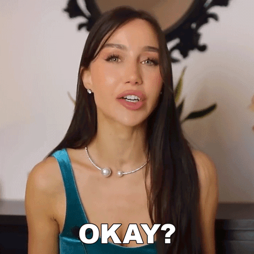 Woman in Blue Top and Pearl Necklace Says Okay