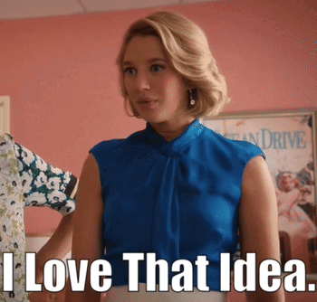 Woman in Blue Top Standing in Front of I Love That Idea Sign