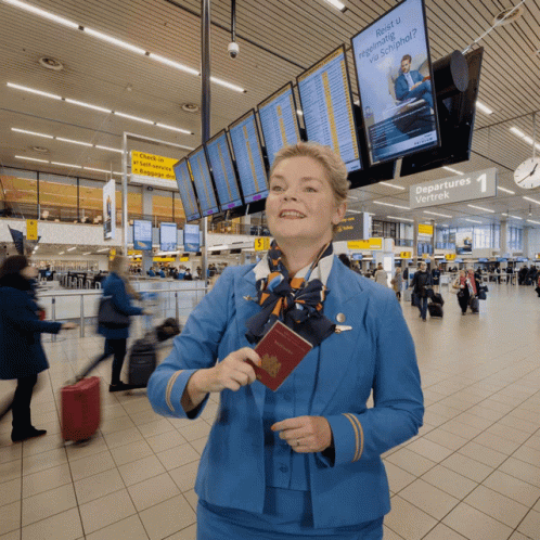 Woman in Blue Uniform Holding Passport at Departures Vertrek Sign