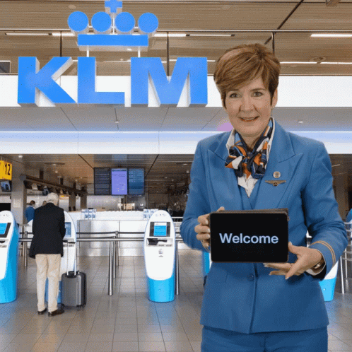 Woman in Blue Uniform Holding Tablet Saying Welcome