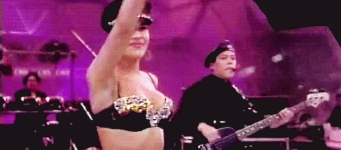 Woman in Bra Dancing While Man Plays Guitar