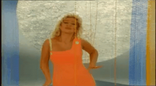 Woman in Bright Orange Dress Dancing Blue Wall