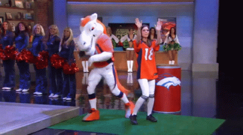 Woman In Broncos Jersey Next To Mascot On Stage GIF