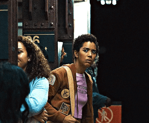 Woman In Brown Jacket And Purple Shirt Saying Aventura GIF