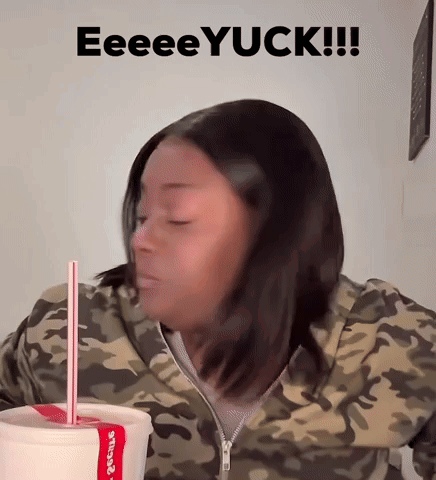 Woman in Camo Jacket Drinking Yuck